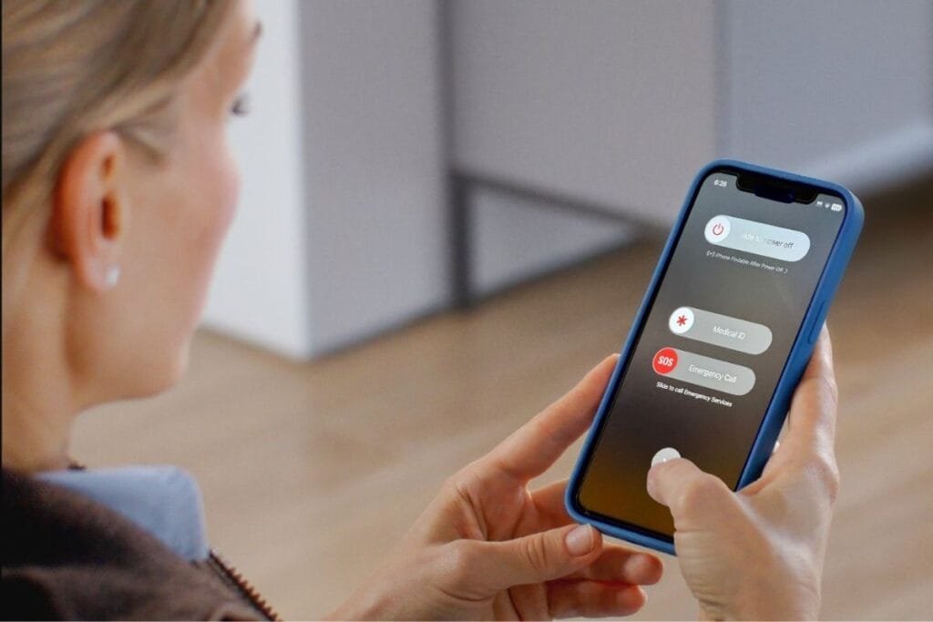 Women holding an iPhone. Emergency SOS on iPhone screen.