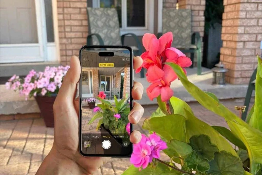 A hand holding an iPhone with Camera on the screen taking a picture using the AE/AF Lock as an example of how to take a good photo on iPhone using AE/AF Lock.