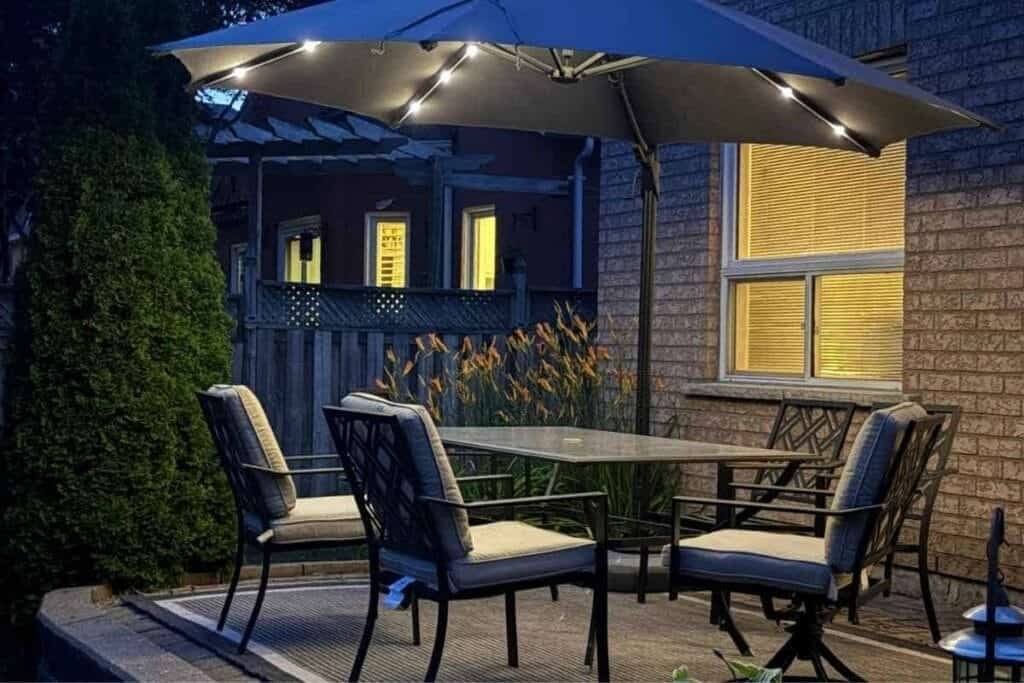 Backyard at night with a patio set showing using lights from umbrella as a light source