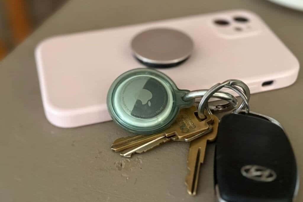 Apple AirTag on a set of keys on a table with an iPhone to demonstrate how do AirTags work.