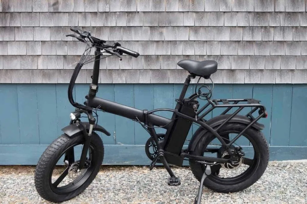Use an AirTag on your bike A black E-bike parked against a building as an example to use an AirTag on your bike.