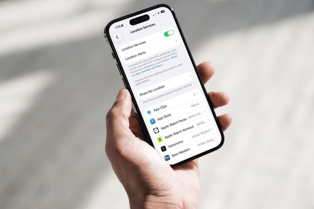 Location Services causing iPhone battery to drain quickly hand holding an iPhone with the location services setting on the screen as an example of how changing this setting can help reduce iPhone battery draining quickly.