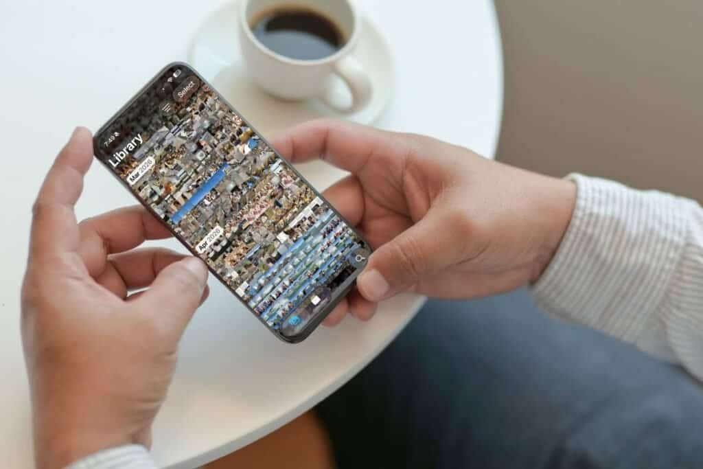 An iPhone screen showing the photo library with a lot of photos as an example of changing the way you think about organizing photos on iPhone.