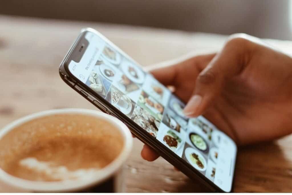 A person holding an iPhone scrolling through the camera roll as an example of organizing photos while you are looking at them.